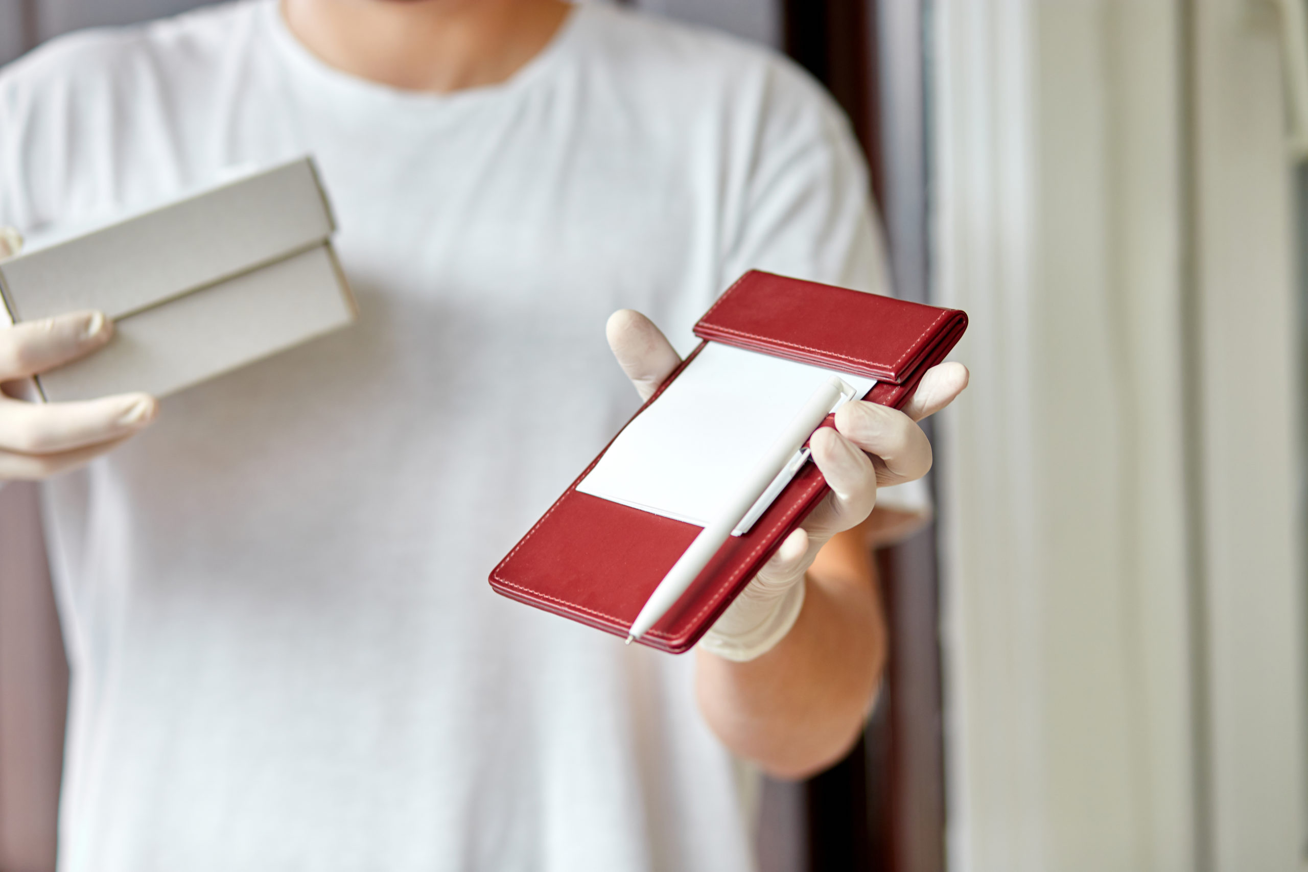 Courier, delivery man in medical latex gloves safely delivers online purchases during coronavirus epidemic.