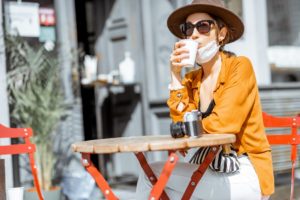 Woman in facial protective mask at the cafe outdoors
